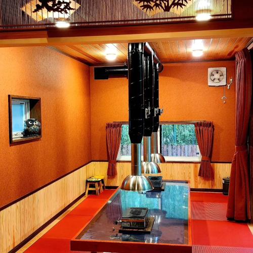 a dining room with orange walls and a glass table at あかがね荘別邸 in Sumino