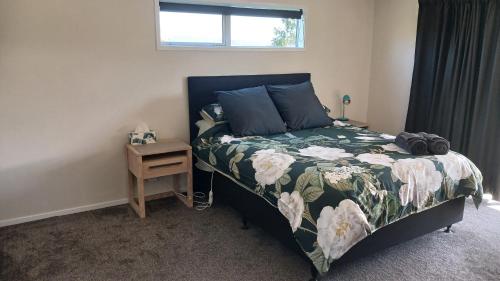 a bedroom with a bed and a night stand at THE GUEST HOUSE - Awakeri modern country cottage in Awakeri