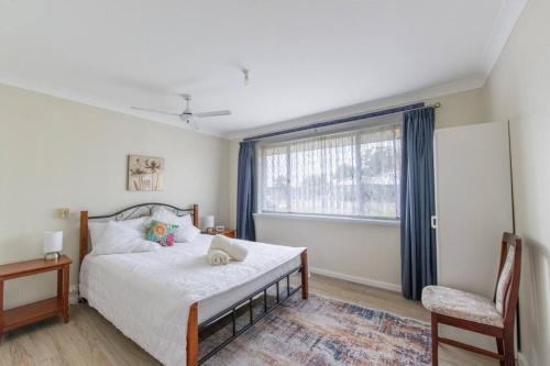 a bedroom with a bed and a chair and a window at Mandurah Island Retreat in Wannanup