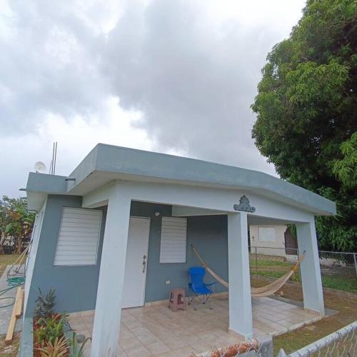 Una pequeña casa azul con una hamaca. en Casa completa, privada con piscina, en Maunabo