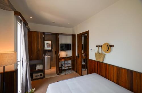 a bedroom with a bed and a room with a desk at Nexus House Nguyen Binh Khiem - Near Saigon Zoo & Botanical Gardens in Ho Chi Minh City