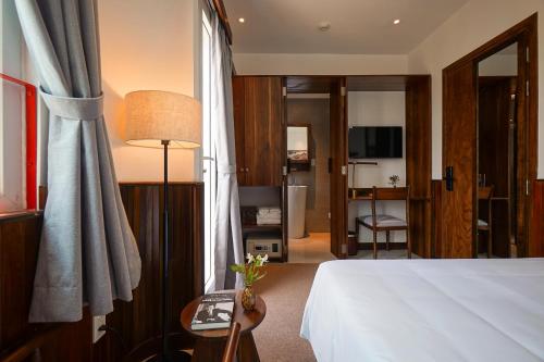 a hotel room with a bed and a table with a lamp at Nexus House Nguyen Binh Khiem - Near Saigon Zoo & Botanical Gardens in Ho Chi Minh City