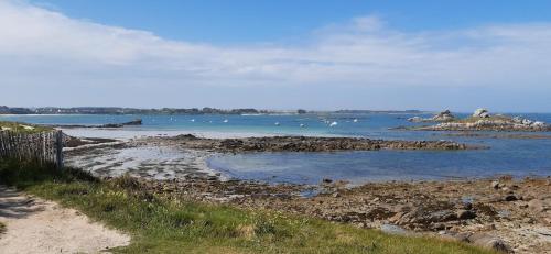 a beach with a bunch of rocks in the water at Theven Plages in Santec