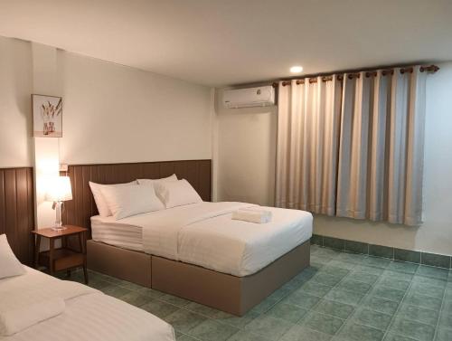 a hotel room with two beds and a window at Matinee House Hatyai in Hat Yai