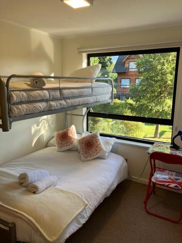 a bedroom with a bunk bed and a window at Casa Tipo Town House in Pucón