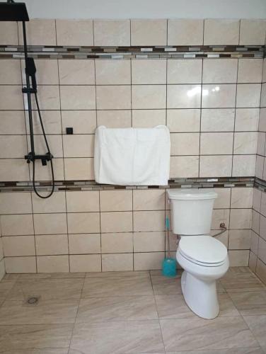 a bathroom with a white toilet and a towel at The Blue Resort in Yaoundé