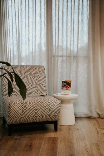 a chair and a table in a room with a window at Nagambie Waterfront Motel in Nagambie