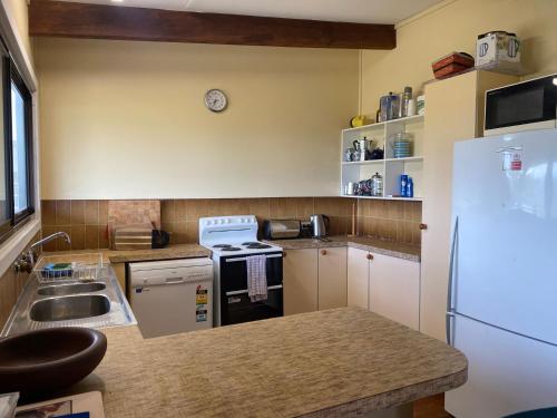 a kitchen with a white refrigerator and a sink at Island Views in Manyana