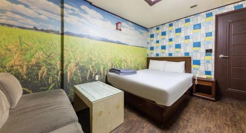 a bedroom with a bed and a painting on the wall at Cheonan Terminal Comodo in Cheonan