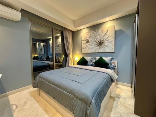 a bedroom with a large bed and a mirror at Gold Coast Apartment PIK Luxury Sea View by stay with E in Jakarta