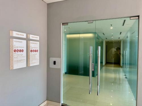 a glass shower in a room with a hallway at Gold Coast Apartment PIK Luxury Sea View by stay with E in Jakarta