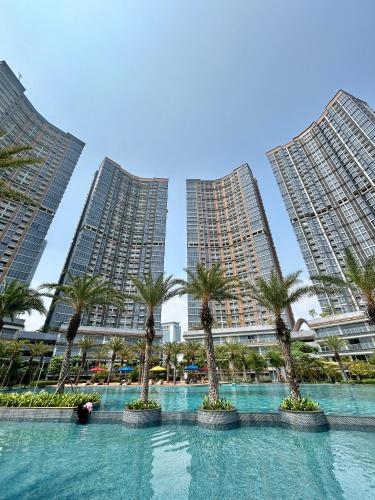 a group of palm trees in front of tall buildings at Gold Coast Apartment PIK Luxury Sea View by stay with E in Jakarta
