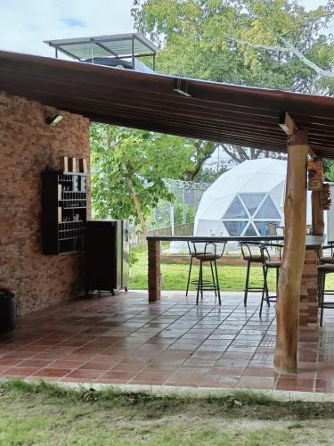 a patio with a table and a glass dome at Glamping el rincon de monocuco in Aguachica