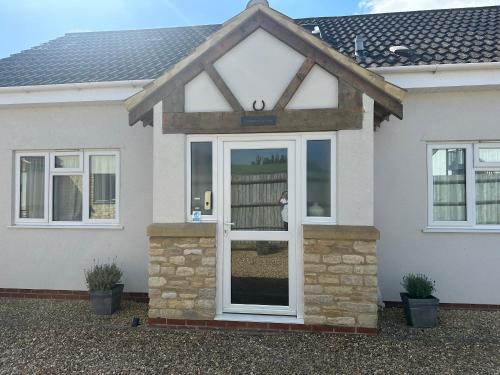 a white door on a white house at Old Groom's Cottage in Witney