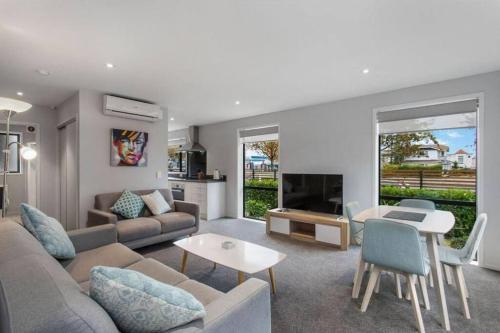 a living room with a couch and a table at Bealey Delight in Christchurch
