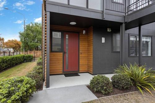 a house with a red door on the side of it at Bealey Delight in Christchurch