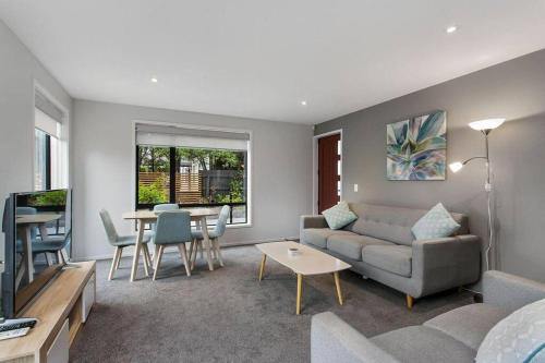 a living room with a couch and a table at Bealey Delight in Christchurch