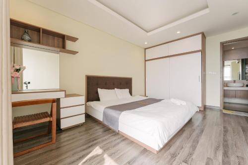 a bedroom with a large white bed and a desk at Hi-Home Suites - City view Apt in HongKong Tower in Hanoi