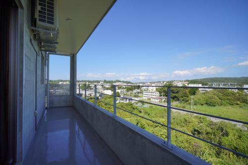 a balcony with a view of a city at CondoYumangi in Onna