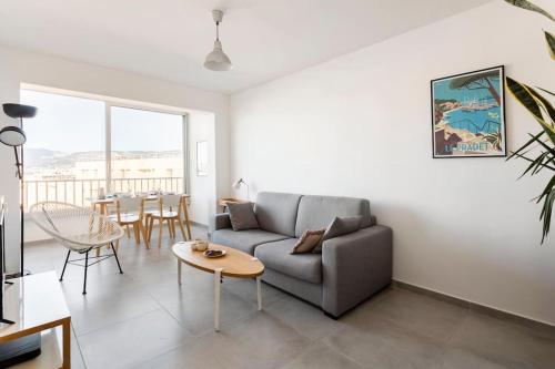 un salon avec un canapé et une table dans l'établissement Cosy T2 vue mer 50m plages Wifi parking, à Saint-Mandrier-sur-Mer