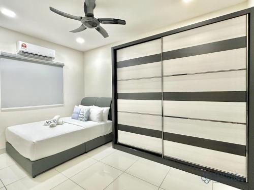 a bedroom with a bed and a ceiling fan at Landed Austin Homestay 11 Pax KTV Mahjong BBQ Glenmarie by Stayrene in Johor Bahru