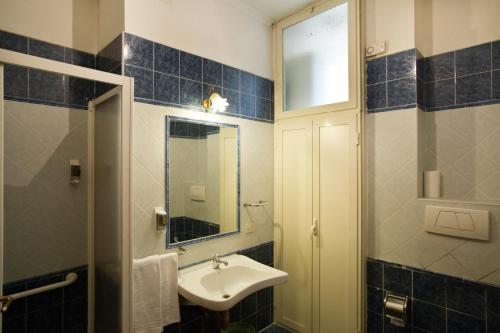 La salle de bains est pourvue d'un lavabo et d'un miroir. dans l'établissement Hotel Lella, à Rome