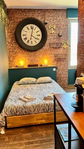 a bedroom with a bed with a clock on the wall at Nos studios au centre ville à Dole in Dole