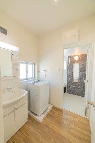 a white bathroom with a sink and a shower at 無料レンタカー付 ReHaQ宮古島バケーションレンタルハウス in Miyako-jima
