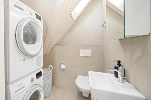a bathroom with a washing machine and a sink at STAYY Flagship Limmattal - contactless check-in in Schlieren