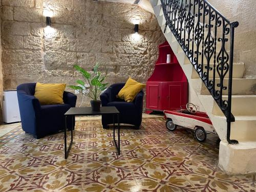a living room with two chairs and a staircase at Entire Apartment in Cospicua with a Cellar! in Cospicua
