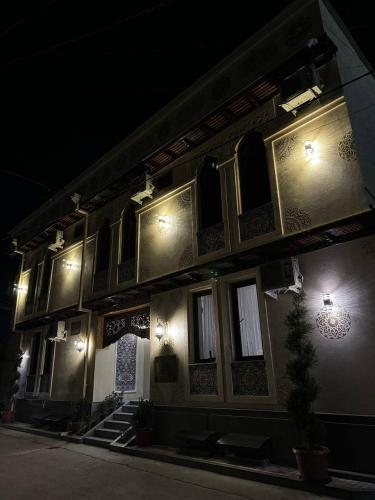 a building with lights on the side of it at night at Altair Boutique in Samarkand