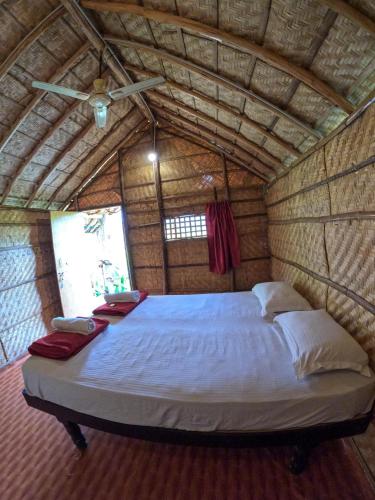 a large bed in a room with a ceiling at Blue Sky Cottages Hampi in Hampi