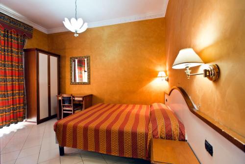 pokój hotelowy z łóżkiem i lampą w obiekcie Hotel Lella w Rzymie