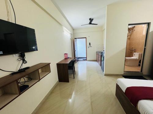 a hotel room with a television and a bedroom at DREAMZ LUXURY HOMe in Kammasandra