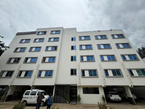 a white building with people standing in front of it at DREAMZ LUXURY HOMe in Kammasandra