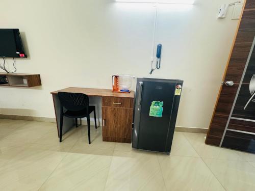 a kitchen with a table and a refrigerator in a room at DREAMZ LUXURY HOMe in Kammasandra