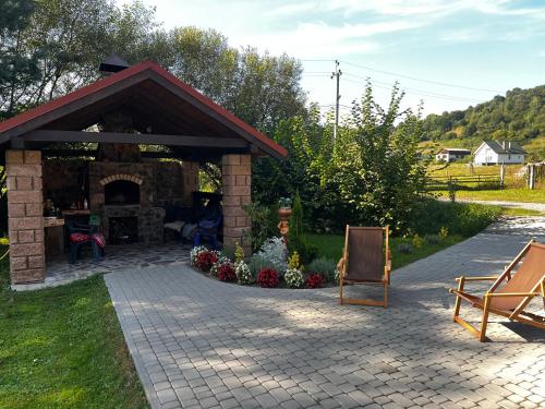 a stone pavilion with a fireplace in a yard at Вербовий двір - Willow Yard in Zhdenievo