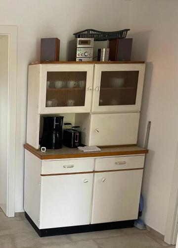 a large white hutch with a coffee maker on it at Mitzis Stubn Apartments - pets no extra cost - Bad Goisern - 24-hour self check-in in Bad Goisern