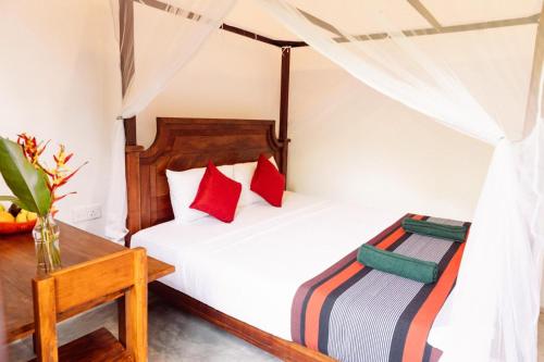 a bedroom with two beds and a table at Hiriketiya Ladina Homestay in Dickwella
