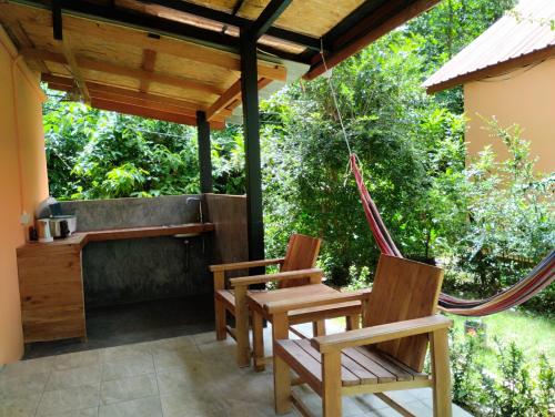 a porch with two chairs and a hammock at Zabit Bungalow in Ko Lanta