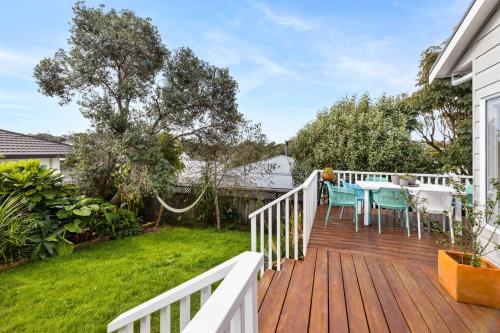 a wooden deck with a table and chairs on it at Peaceful Oasis in the heart of Stanmore Bay in Whangaparaoa