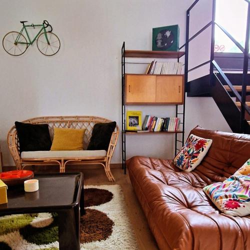 a living room with a couch and a bike on the wall at Paulette à bicyclette in Méry