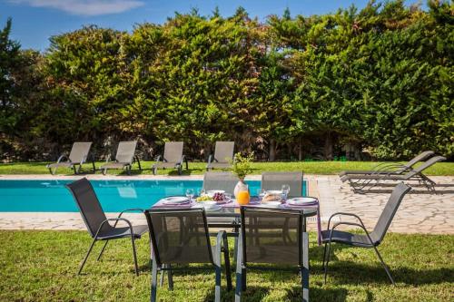 a table and chairs in front of a pool at Sun Villas in Sarlata