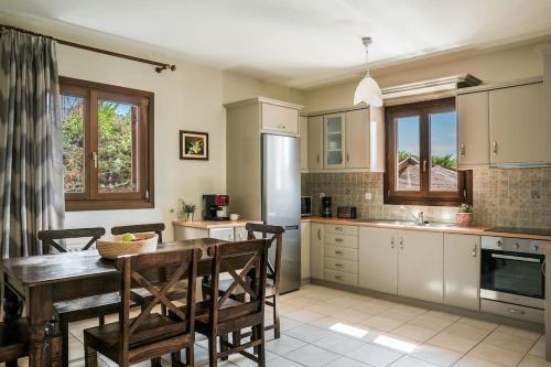 a kitchen with a wooden table and chairs and a kitchen with a sink at Sun Villas in Sarlata