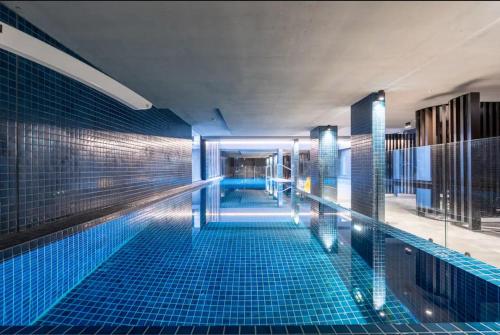 a swimming pool in a building with blue tiles at Little Midnight 2 in Canberra