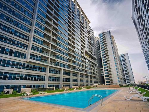 un gran edificio con una piscina y dos edificios altos en Luxury Holiday Home Just Minutes from Dubai's Global Village Your Perfect Getaway!", en Dubái
