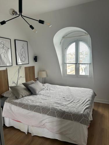 une chambre avec un grand lit avec une fenêtre dans l'établissement Paris Trocadéro, à Paris