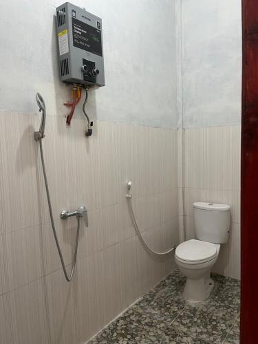 a bathroom with a toilet and a shower in it at Para para cafe & cottage in Berastagi