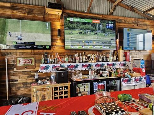 a bar with a large screen on the wall at Trawalla Farm Stays - Entire House and Large Pool Bar - Perfect for Groups in Bywong