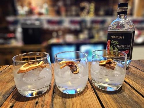 two glasses of water and a bottle of gin at Trawalla Farm Stays - Entire House and Large Pool Bar - Perfect for Groups in Bywong